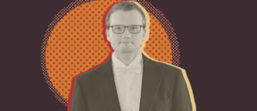 Mies tummassa puvussa ja valkoisessa solmukkeessa oranssin täplitetyn ympyrän ja tumman taustan edessä.